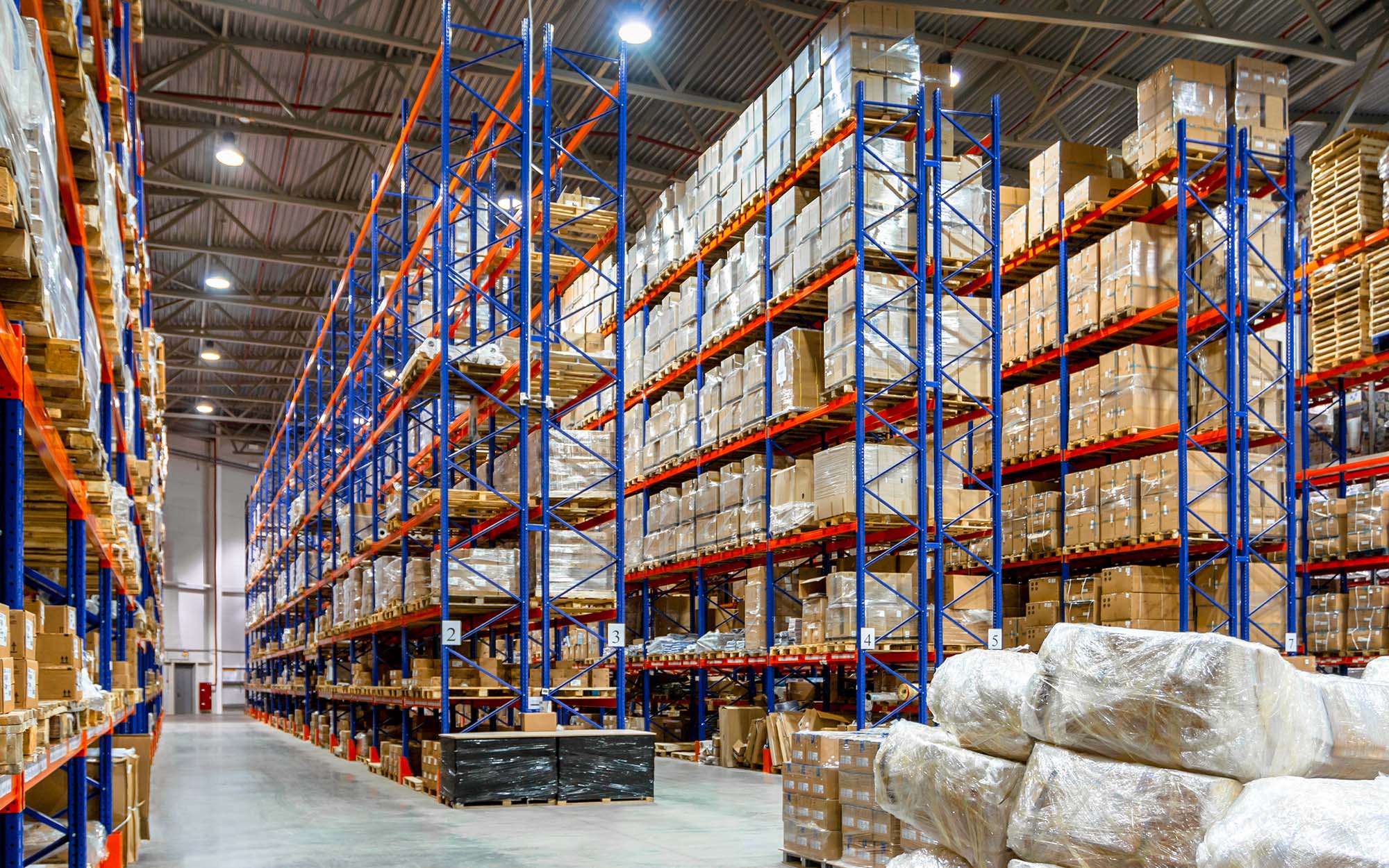 Interior Of A Modern Warehouse Storage Of Retail Shop With Pallet Truck Near Shelves